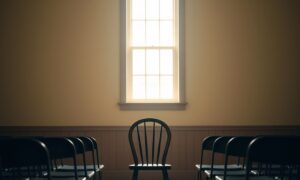 Quiet community hall stage with a single chair representing introverts preparing to speak publicly