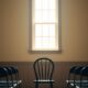 Quiet community hall stage with a single chair representing introverts preparing to speak publicly