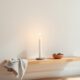 Candle and river stones on a quiet shelf representing learning self discipline as a beginner